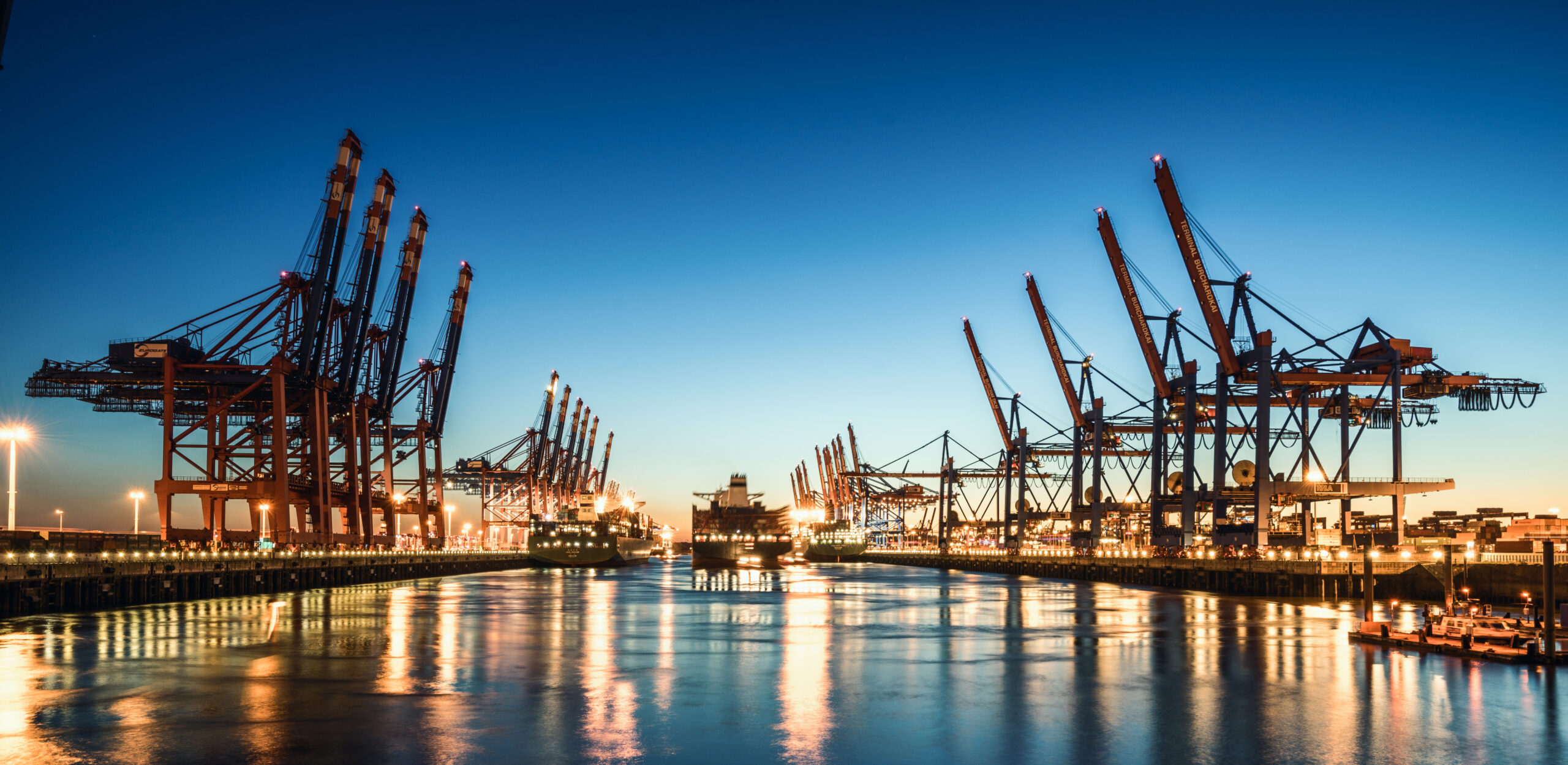 Containerkräne und Hafenbecken im Hamburger Hafen bei Nacht